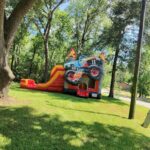 Monster truck bounce house and slide combo on a lawn in Montgomery County